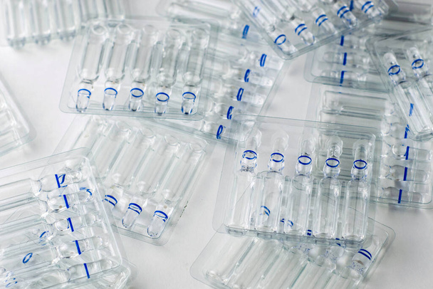 пластикові прозорі контейнери зі скляними ампулами на білому фоні. Високоякісна фотографія
 - Фото, зображення