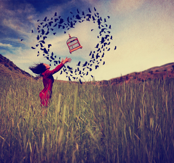 Girl in field tossing birdcage - Zdjęcie, obraz
