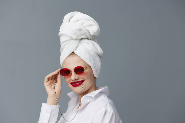 portrait of a woman red glasses towel on head makeup isolated background - Valokuva, kuva