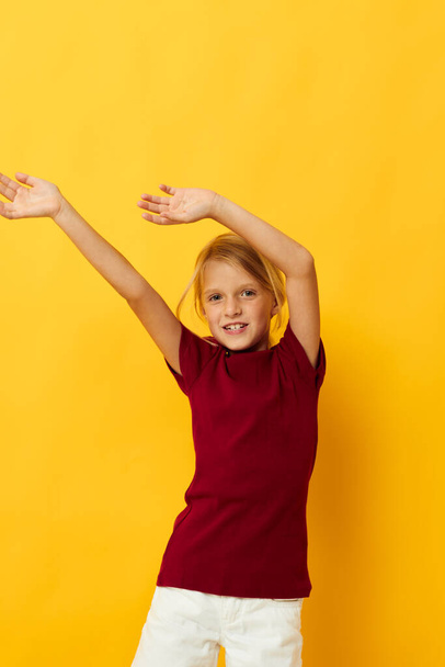 cheerful girl with blond hair gesturing with her hands yellow background - Zdjęcie, obraz
