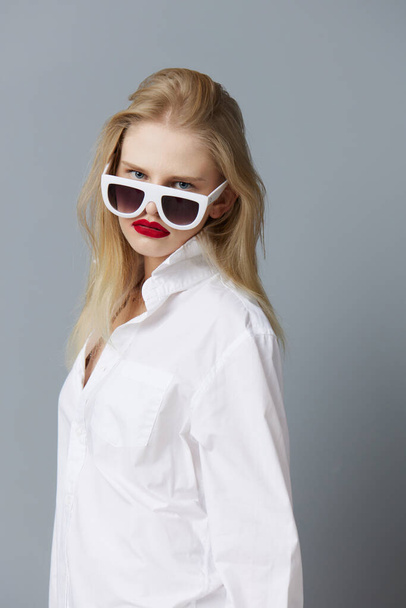 гарна жінка в сонцезахисних окулярах білої сорочки ізольований фон
 - Фото, зображення