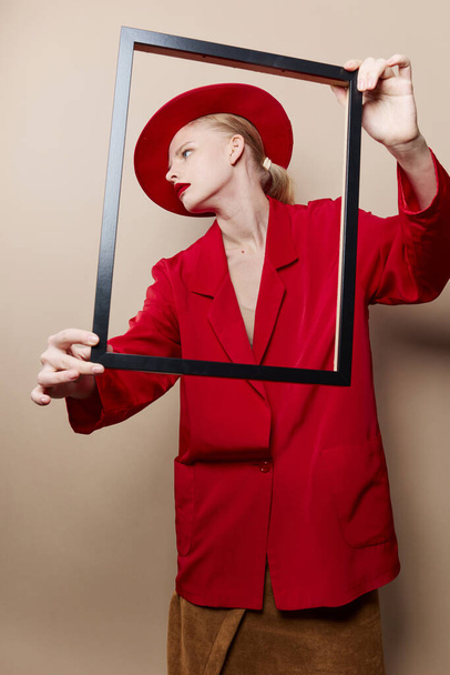 pretty woman frame in hand in red hat and jacket isolated background - Photo, Image