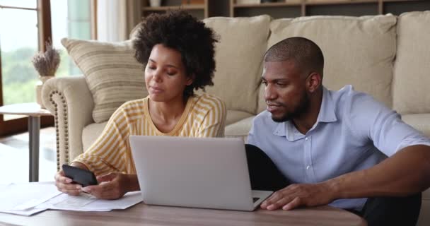 Afro American spouses calculate bills by laptop at home office - Video, Çekim