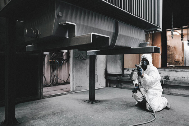 工場の職員は職場で化学防護服を着用する。塗料噴霧. - 写真・画像
