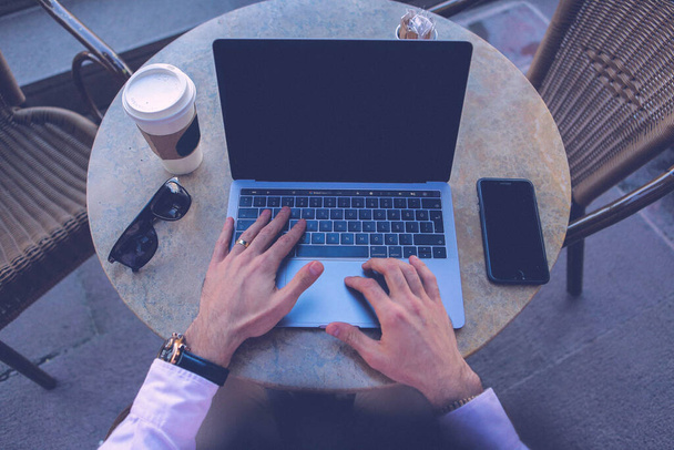 Man using laptop with blank white desktop screen  - Foto, afbeelding