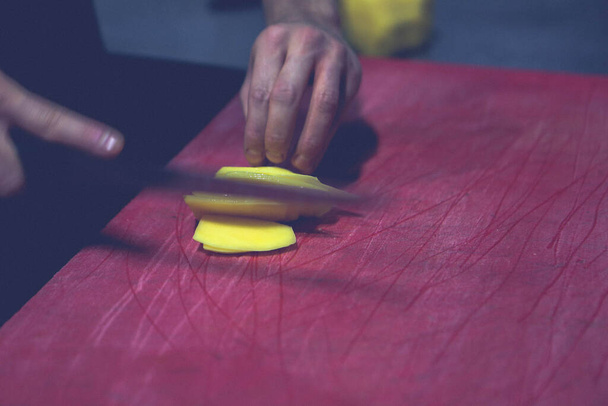 Человек рубит картошку для приготовления пищи.. - Фото, изображение