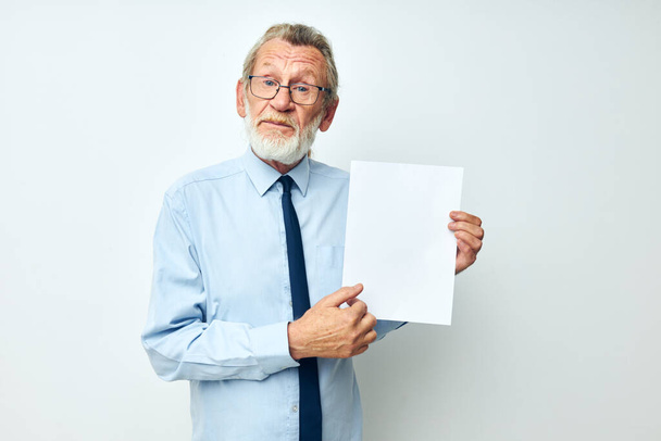 Senior grey-haired man in a shirt with a tie copy-space sheet of paper isolated background - Fotografie, Obrázek
