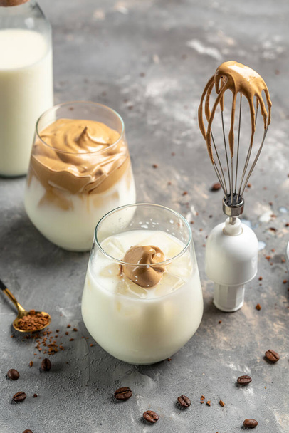 Metal balloon whisk with whipping instant Dalgona coffee. frothy coffee trend korean drink latte espresso with coffee foam, fluffy creamy whipped coffee. top view. - Photo, Image