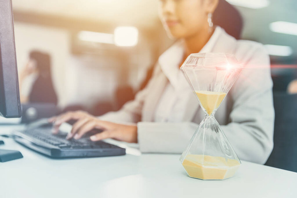 Business Woman Αγώνας εργασίας ενάντια στο χρόνο με Times Hourglass στο ρολόι γραφείου για τις ώρες εργασίας γραφείου Concept - Φωτογραφία, εικόνα
