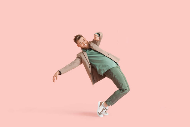 Cool dancing young man on color background - 写真・画像