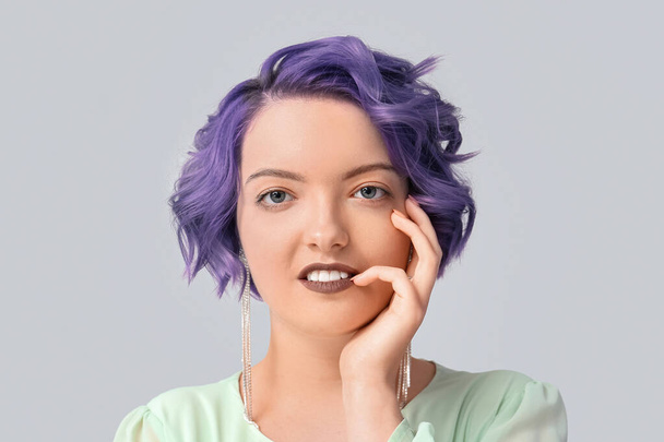 Bella giovane donna con capelli viola su sfondo chiaro. Very Peri - colore dell'anno 2022 - Foto, immagini