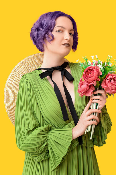 Belle jeune femme aux cheveux violets et bouquet de fleurs sur fond jaune. Very Peri - couleur de l'année 2022 - Photo, image