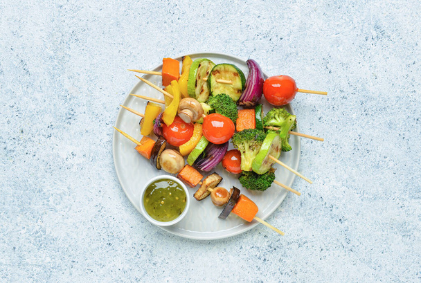 Plate with tasty vegetable skewers and sauce on light background - Photo, Image