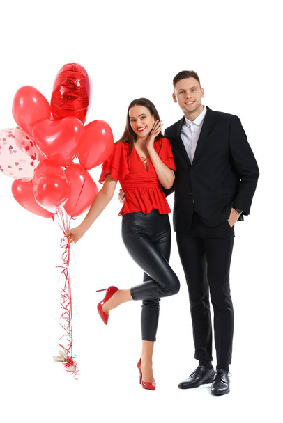 Happy young couple with balloons on white background. Valentine's Day celebration - Фото, изображение