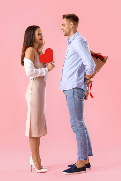 Jongeman groet zijn vriendin voor Valentijnsdag op kleur achtergrond - Foto, afbeelding