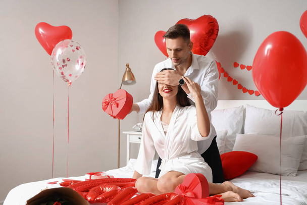 Young man greeting his girlfriend for Valentine's Day at home - Photo, Image
