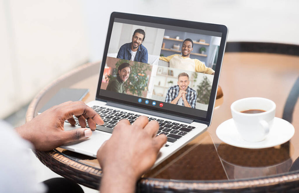 Communicatie op afstand. Onherkenbare zwarte man met laptop in Cafe met video conferentie - Foto, afbeelding