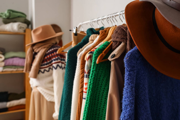 Bastidor con suéteres calientes y sombreros en vestidor, primer plano - Foto, Imagen