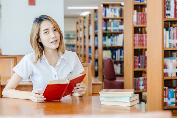 Portrét asijské univerzity teen dívka v knihovně šťastný úsměv - Fotografie, Obrázek