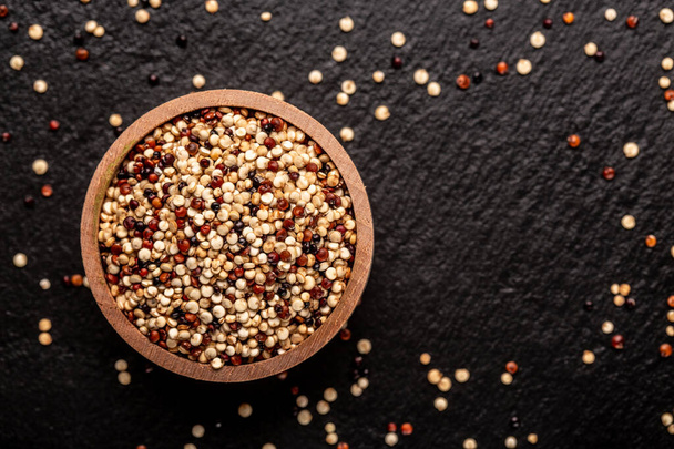 mixed raw quinoa in bowls on wooden background. Healthy and gluten free food. Origin Peru, banner, menu, recipe, place for text. top view. - Photo, Image