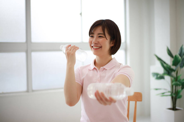 jovem asiático mulher com água garrafas exercício - Foto, Imagem