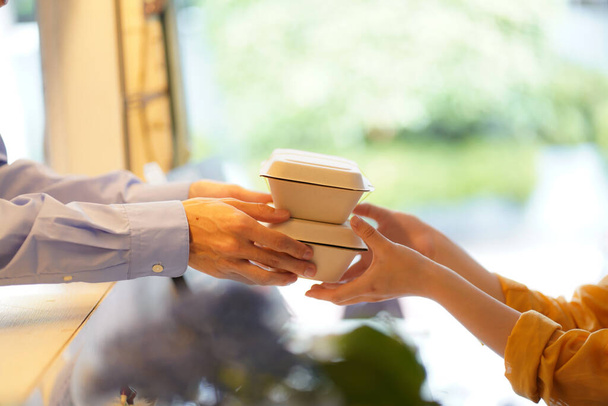 cropped image of hands holding containers with food - Photo, Image