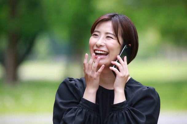 portrait of a young asian woman talking on the phone  - 写真・画像