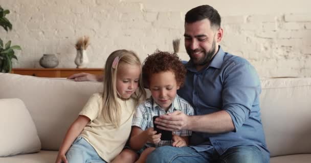 Αξιαγάπητα παιδιά και ο πατέρας περνούν δωρεάν ελεύθερο χρόνο χρησιμοποιούν κινητό τηλέφωνο - Πλάνα, βίντεο