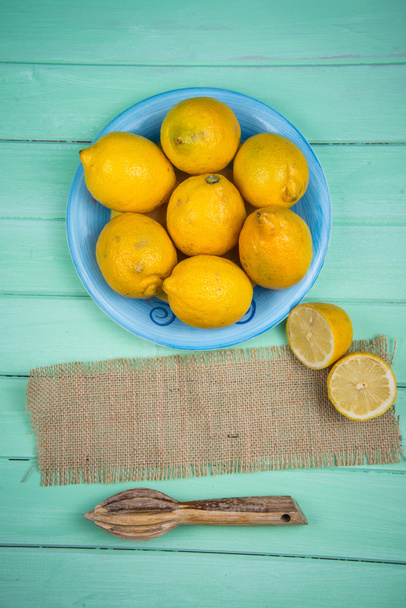 Organic lemons and juice squeezer on table - Photo, Image
