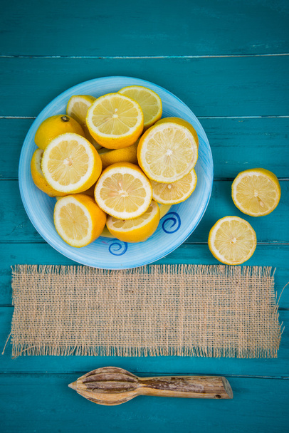 Organic lemons  halves and juice squeezer on table - Zdjęcie, obraz