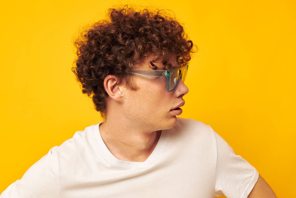 cute red-haired guy in blue glasses white t-shirt fashion modern style yellow background unaltered - 写真・画像