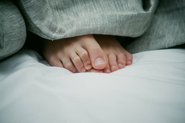 pies de bebé en la cama de cerca - Foto, Imagen