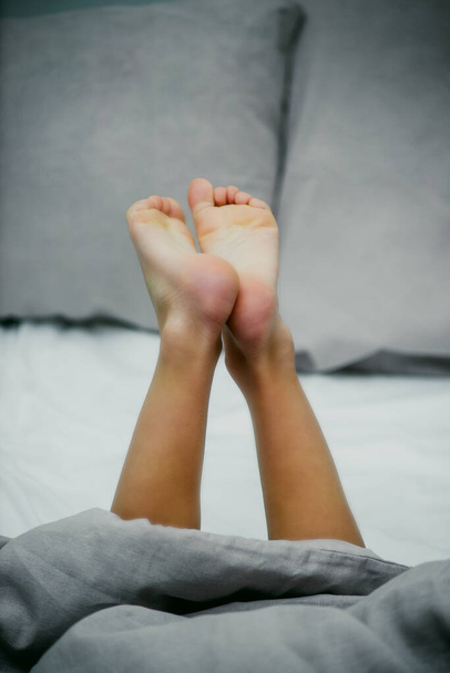 little baby feet on light bedding close-up - Fotografie, Obrázek