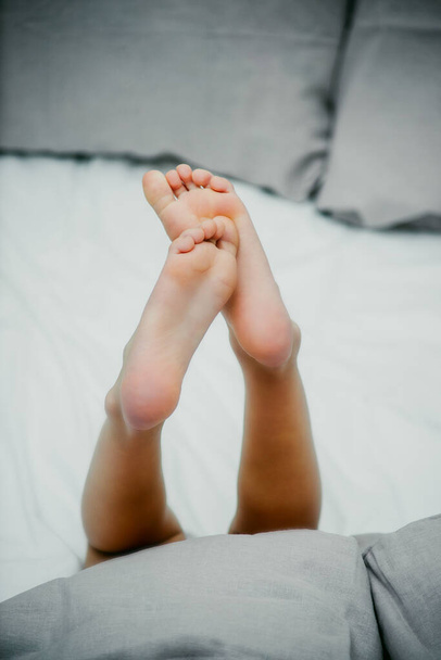 pies de bebé en la cama de cerca - Foto, imagen