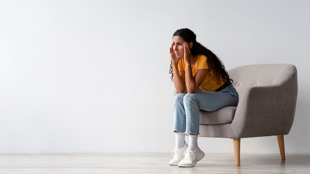 Masennuksen käsite. Järkytys Huolestunut nuori nainen istuu nojatuoli kotona - Valokuva, kuva