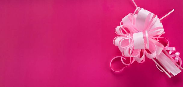 Sanft rosa Hintergrund mit einem üppigen Bogen Draufsicht. Viel Platz für Text, Kopierraum. Einfache Dekoration, um Geschenkschachtel und Postkarte zu verschönern, flache Lage. - Foto, Bild