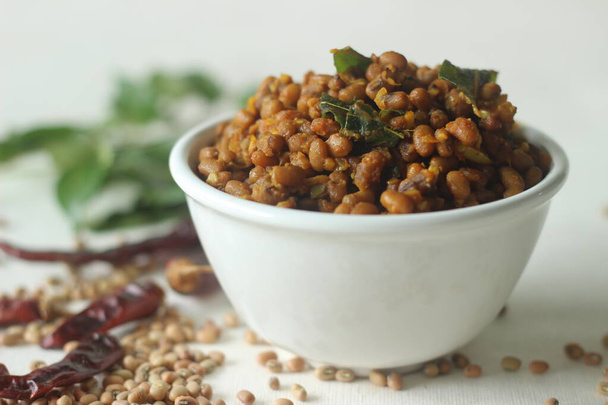 Boiled red cowpea beans stir fried with shallots and garlic. Popular side dish for meals in Kerala commonly called Stir fried Vanpayar. Shot on white background - Photo, Image