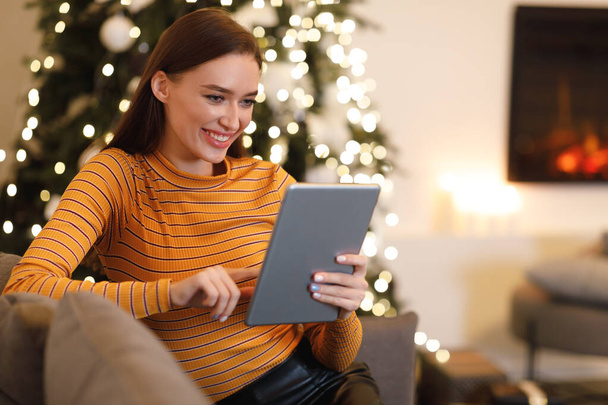Sorrindo jovem mulher usando tablet digital em casa - Foto, Imagem