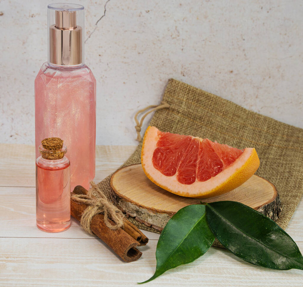 Grapefruit pieces, pink shower gel, essential oil and cinnamon. The concept of natural cosmetics - Foto, Imagem