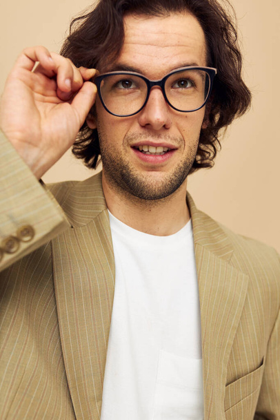 Homme attrayant avec des lunettes émotions geste mains posant fond beige - Photo, image
