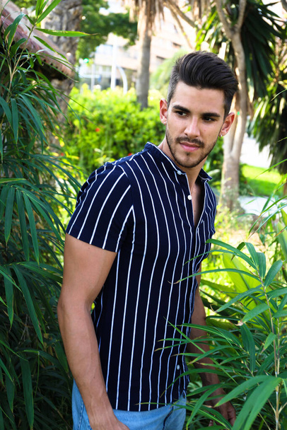 handsome dark-haired guy with a beard posing as a model in the city of Alicante in with him car - Photo, Image