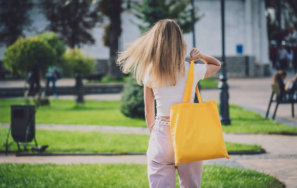 Young beautiful woman with linen eco bag on city background. - Photo, image
