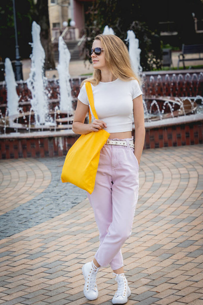 Young beautiful woman with linen eco bag on city background. - 写真・画像