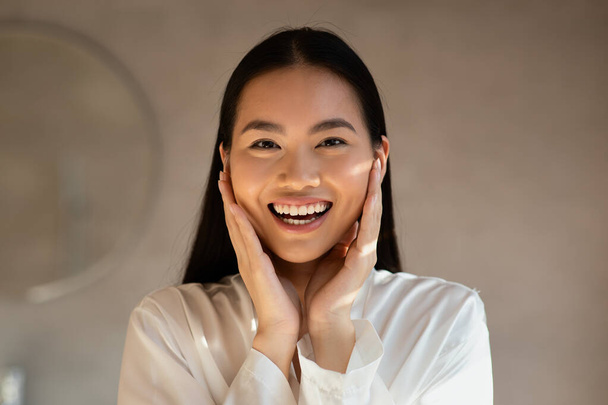 Happy beautiful asian woman enjoying her smooth face skin - Fotó, kép