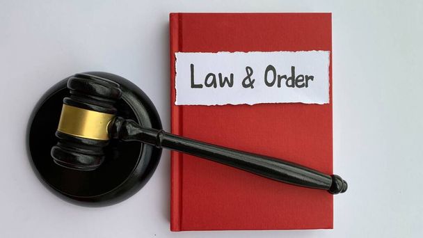 Law and order on torn paper with judge gavel as concept of law and justice. Book with red cover background. - Foto, imagen