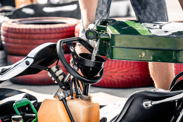 The mechanic go kart racing service pours fuel into the tank - 写真・画像