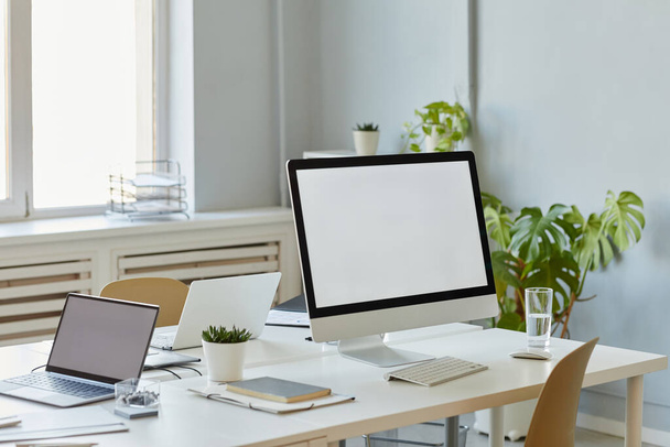 Минимальное фоновое изображение офисного рабочего места с макетом экрана компьютера на белом столе, место для копирования - Фото, изображение