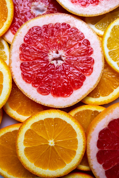 Slises různých citrusů na bílém pozadí. Detailní záběr nakrájených citrusů. - Fotografie, Obrázek