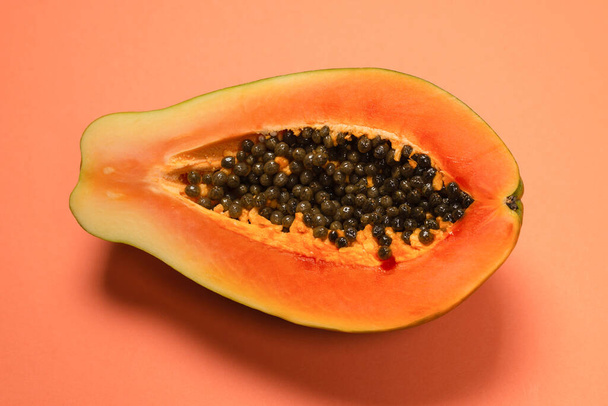 Fruta de la papaya sobre fondo naranja. Fruta tropical. Mitad papaya.  - Foto, Imagen