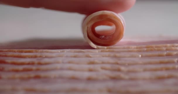 Macro shot de la tranche de bacon est enroulé par le doigt. Plats avec bacon et porc, 4k 60p Prores - Séquence, vidéo